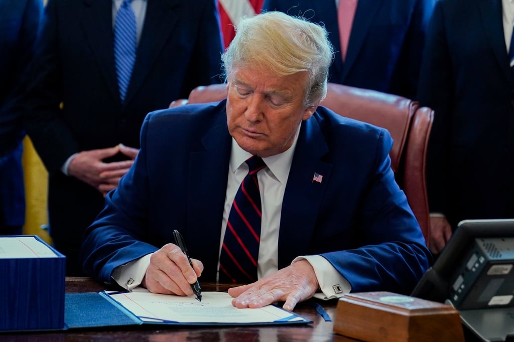 Former President Donald Trump signs the coronavirus stimulus relief package, in the Oval Office at the White House, in March 2020, in Washington DC. Photo: AP Photo Former President Donald Trump signs the coronavirus stimulus relief package, in the Oval Office at the White House, in March 2020, in Washington DC. Photo: AP Photo