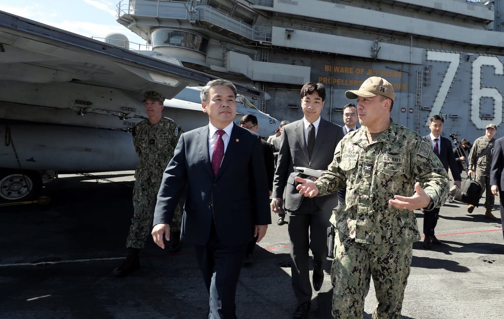 South Korean Defence Minister Lee Jong Sup with US Navy Captain Fred Goldhammer on the main deck of the CVN-76 USS Ronald Reagan. Photo: Defence Ministry via Zuma Press Wire/dpa