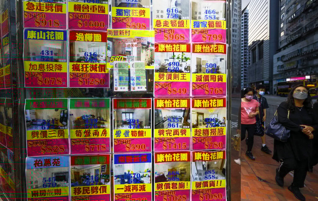 People walk past residential property advertisements displayed in the window of an estate agency in the Taikoo Shing neighbourhood of Hong Kong on October 11, 2022. Photo: SCMP/ Dickson Lee