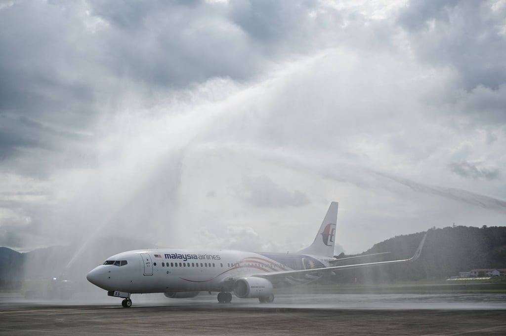 A water salute welcomes Malaysia Airlines aircraft Boeing 738 after its landing in Langkawi from Kuala Lumpur International Airport in September 2021, as the holiday island reopened to domestic tourists, following closures due to restrictions to halt the spread of Covid-19. Photo: AFP