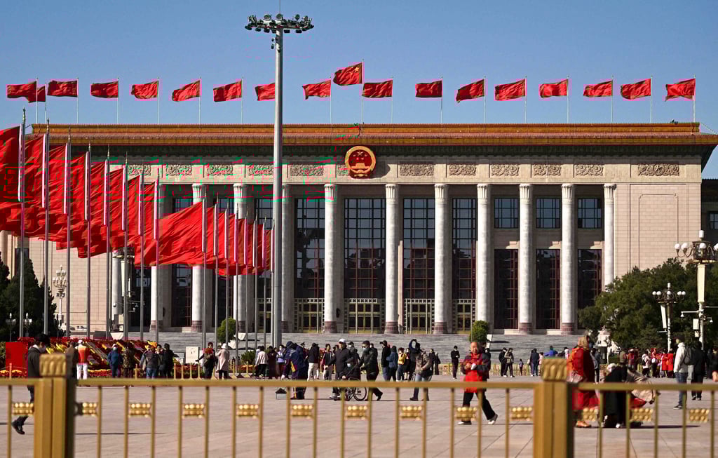 People walk before the Great Hall of the People at Tiananmen Square in Beijing. Photo: AFP