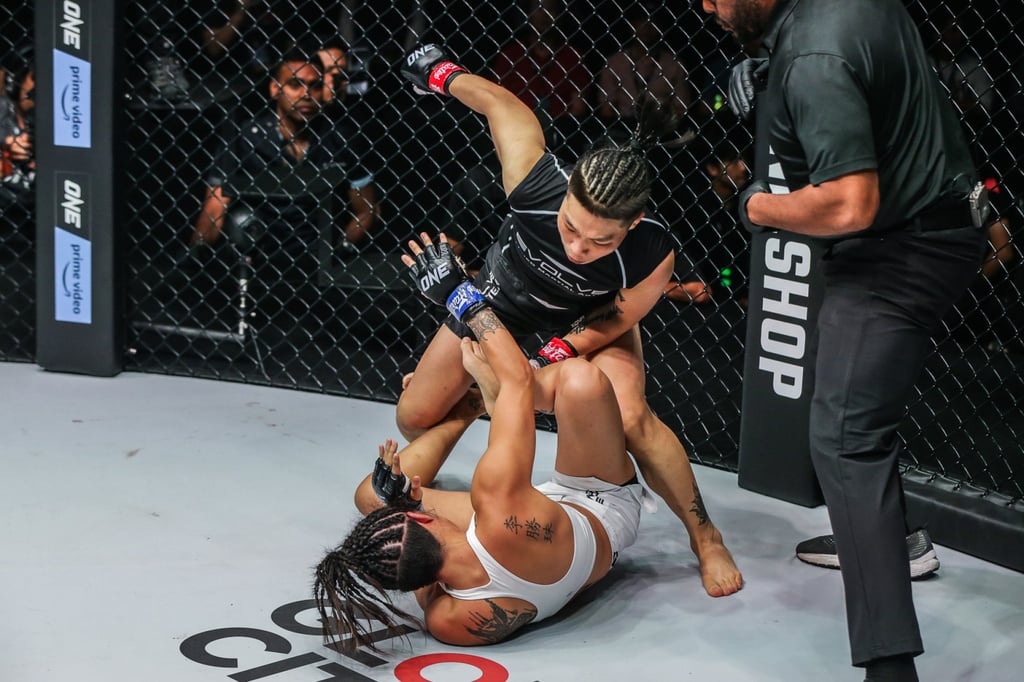 Referee herb Dean looks on as Xiong Jingnan throws ground-and-pound at Angela Lee.