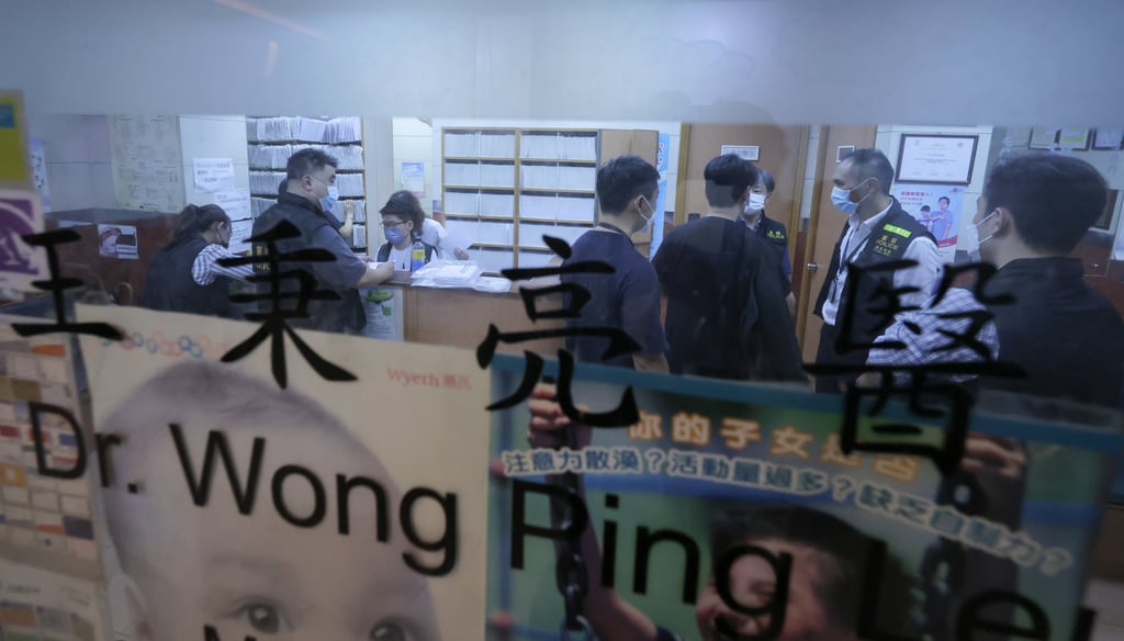 Police officers investigate at the clinic of Dr Wong Ping-leung in Chai Wan. Photo: Jelly Tse / SCMP
