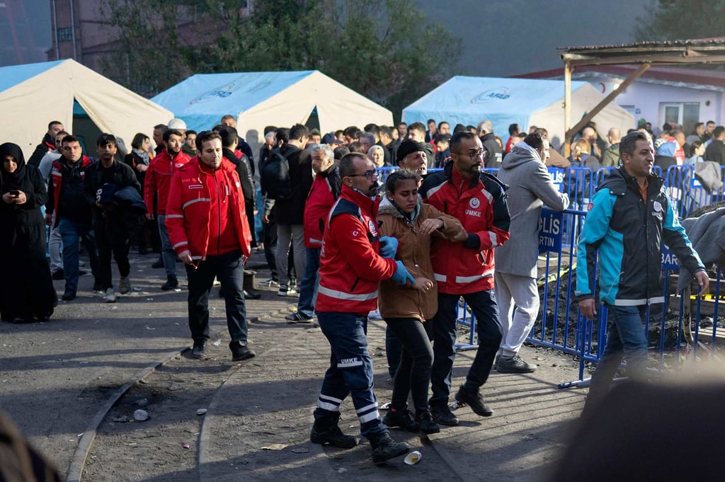 A woman is escorted outside a coal mine after an explosion in Amasra. Some 110 people had been working underground when one of Türkiye’s deadliest industrial accidents in years struck on Friday at sunset. Photo: AFP
