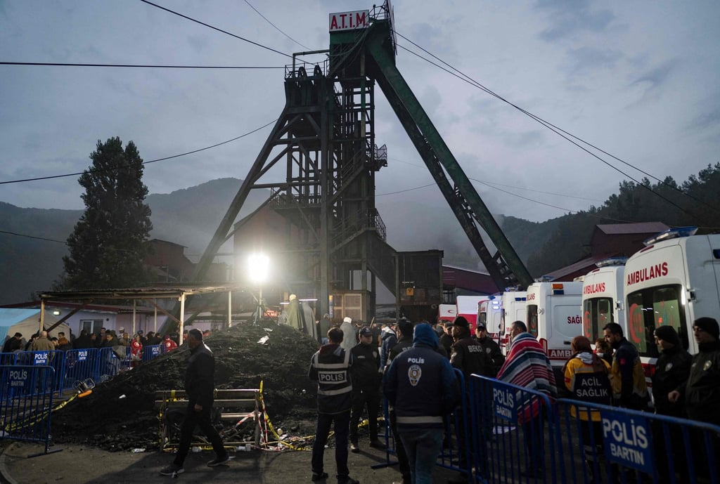 Police officers stand outside the coal mine after an explosion. Rescuers sent in reinforcements from surrounding villages to help in the search and rescue. Photo: AFP