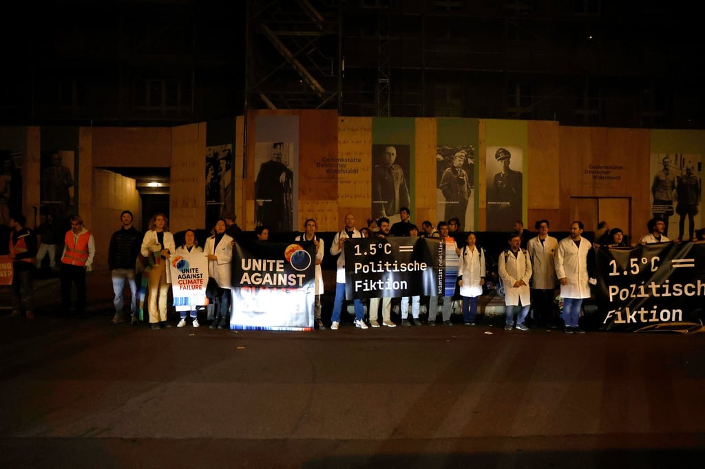Climate activists stand outside the Berlin hotel on Sunday where the World Health Summit is taking place. Photo: dpa