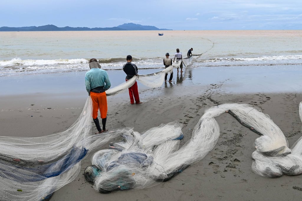 Fishermen pull their net on a beach in Banda Aceh. Good seasons are becoming a rarity for Indonesia’s fishing communities, as global temperatures rise. Photo: AFP