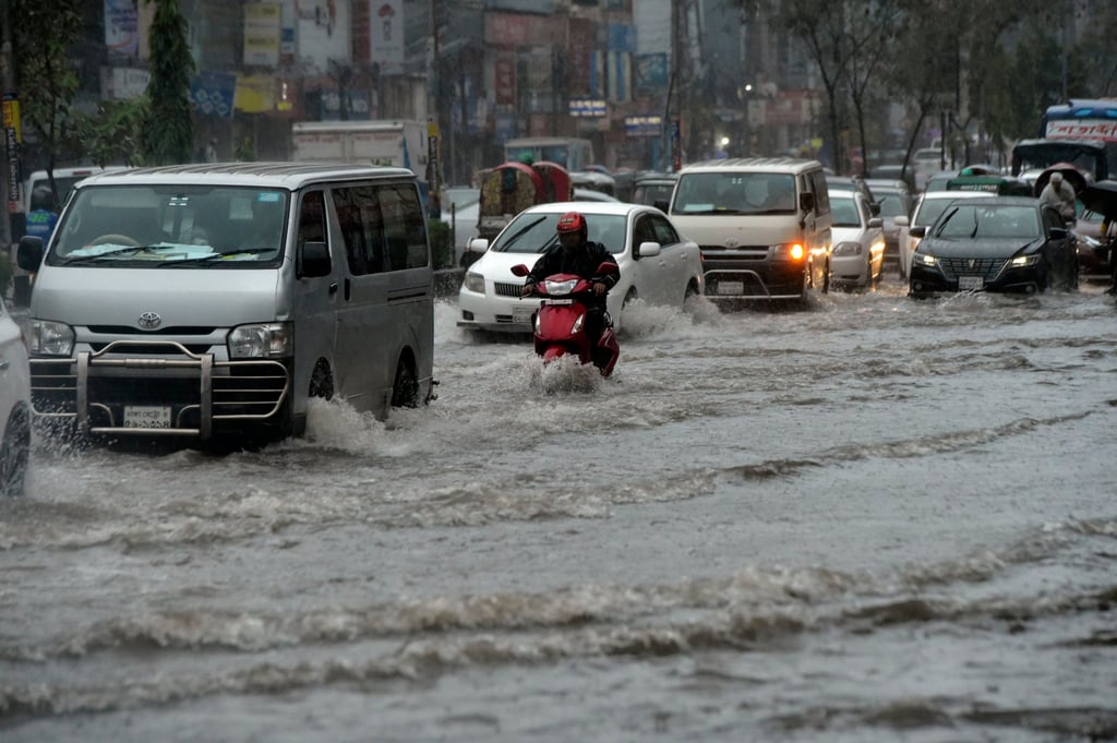 Vehicles pass along a waterlogged street in the Bangladeshi capital Dhaka as Cyclone Sitrang approached on Monday. Photo: Xinhua