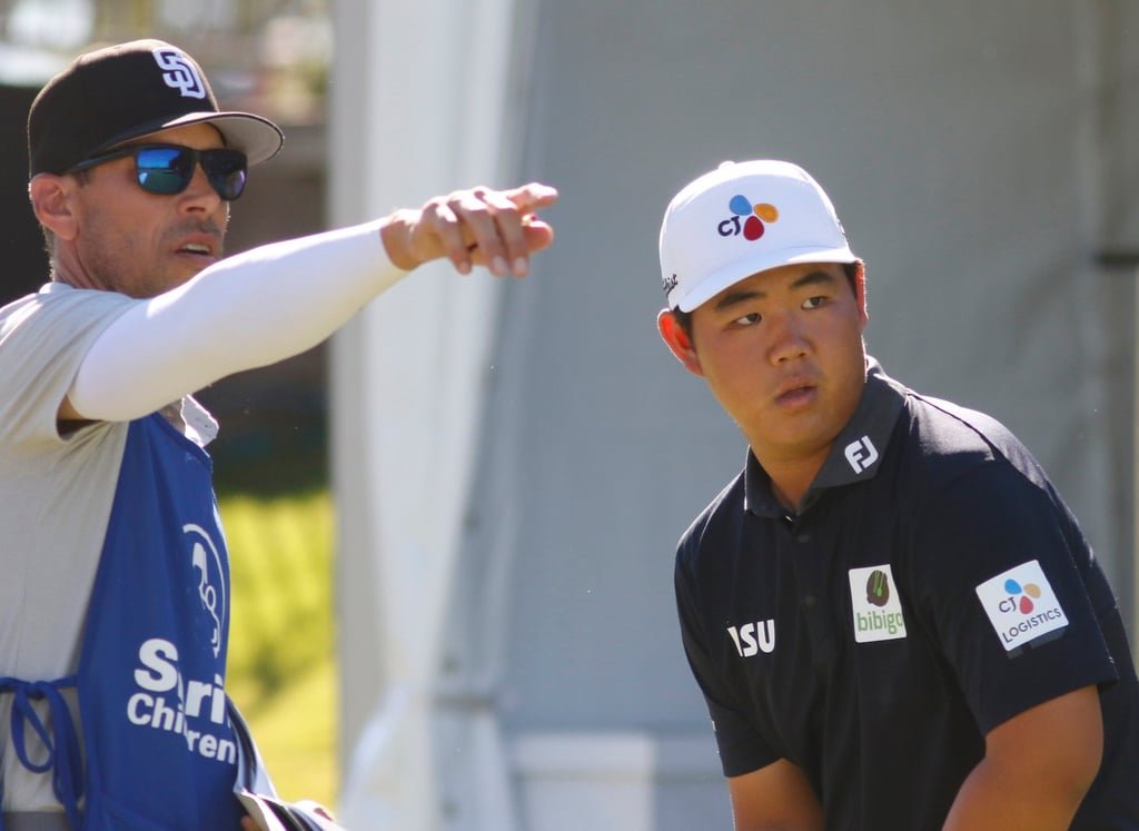 Tom Kim of South Korea, consults his caddie before teeing off at the 10th hole during the second round of the Shriners Children’s Open. Photo: AP