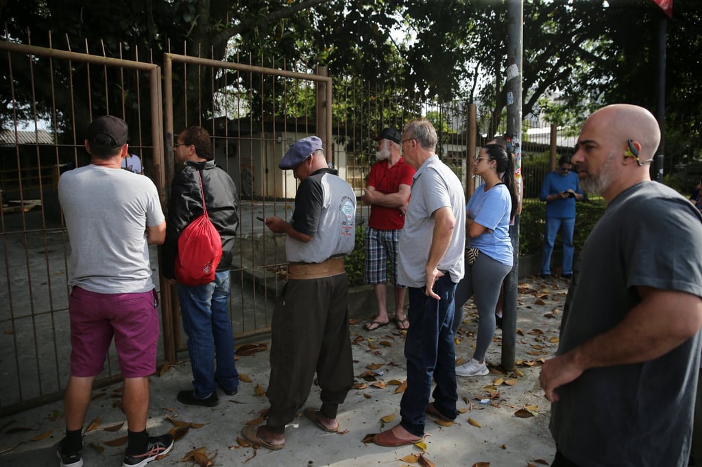 People wait outside a polling station to cast their votes during the presidential election, in Porto Alegre, Brazil on October 30. Photo: Reuters People wait outside a polling station to cast their votes during the presidential election, in Porto Alegre, Brazil on October 30. Photo: Reuters
