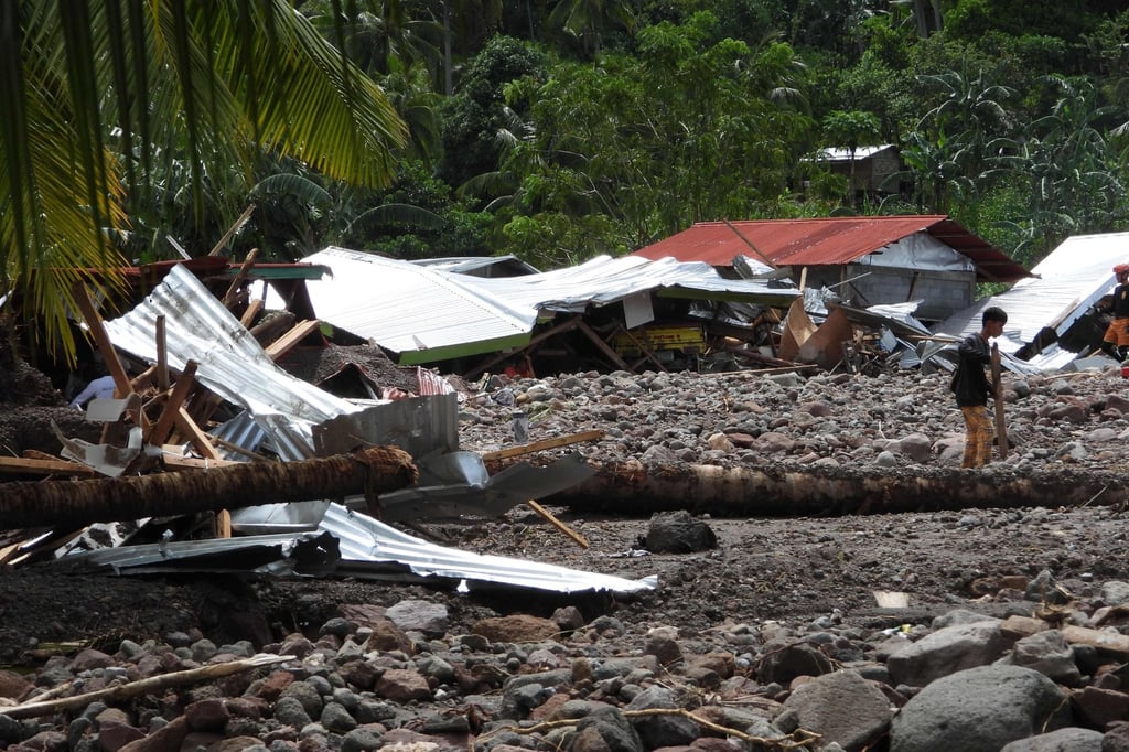 A resident walks past a destroyed house in the landslide-hit village of Kusiong in the southern Philippines’ Maguindanao province on Saturday. Photo: AFP