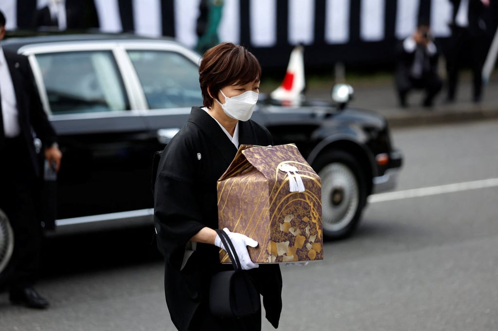 Akie Abe, wife of former Prime Minister Shinzo Abe carries a cinerary urn as she arrives at the state of funeral of her husband on September 27, 2022. Photo: Pool via Reuters