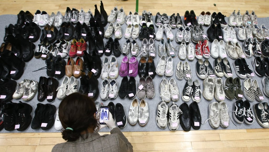 A police officer in Seoul documents shoes collected from the scene of the Halloween crush. Photo: EPA-EFE
