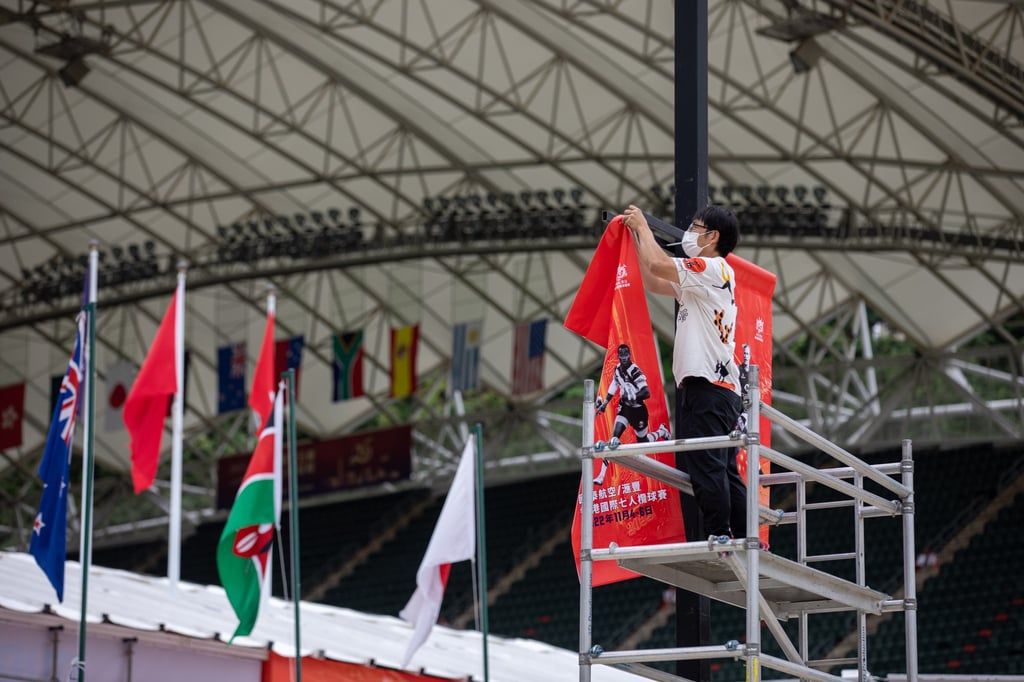 A worker installs promotional posters outside Hong Kong Stadium ahead of the 2022 Cathay Pacific/HSBC Hong Kong Sevens. Photo: EPA-EFE