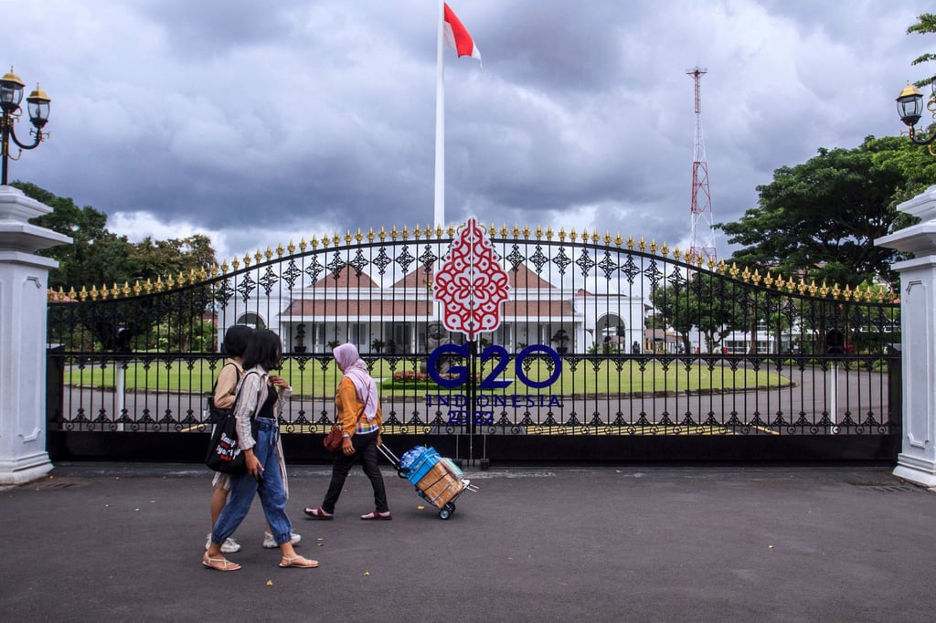 People walk past the main gate of the Palace of Yogyakarta, which has been prepared to welcome next week’s G20 summit to be hosted by Indonesia. Photo: AFP/Getty Images/TNS