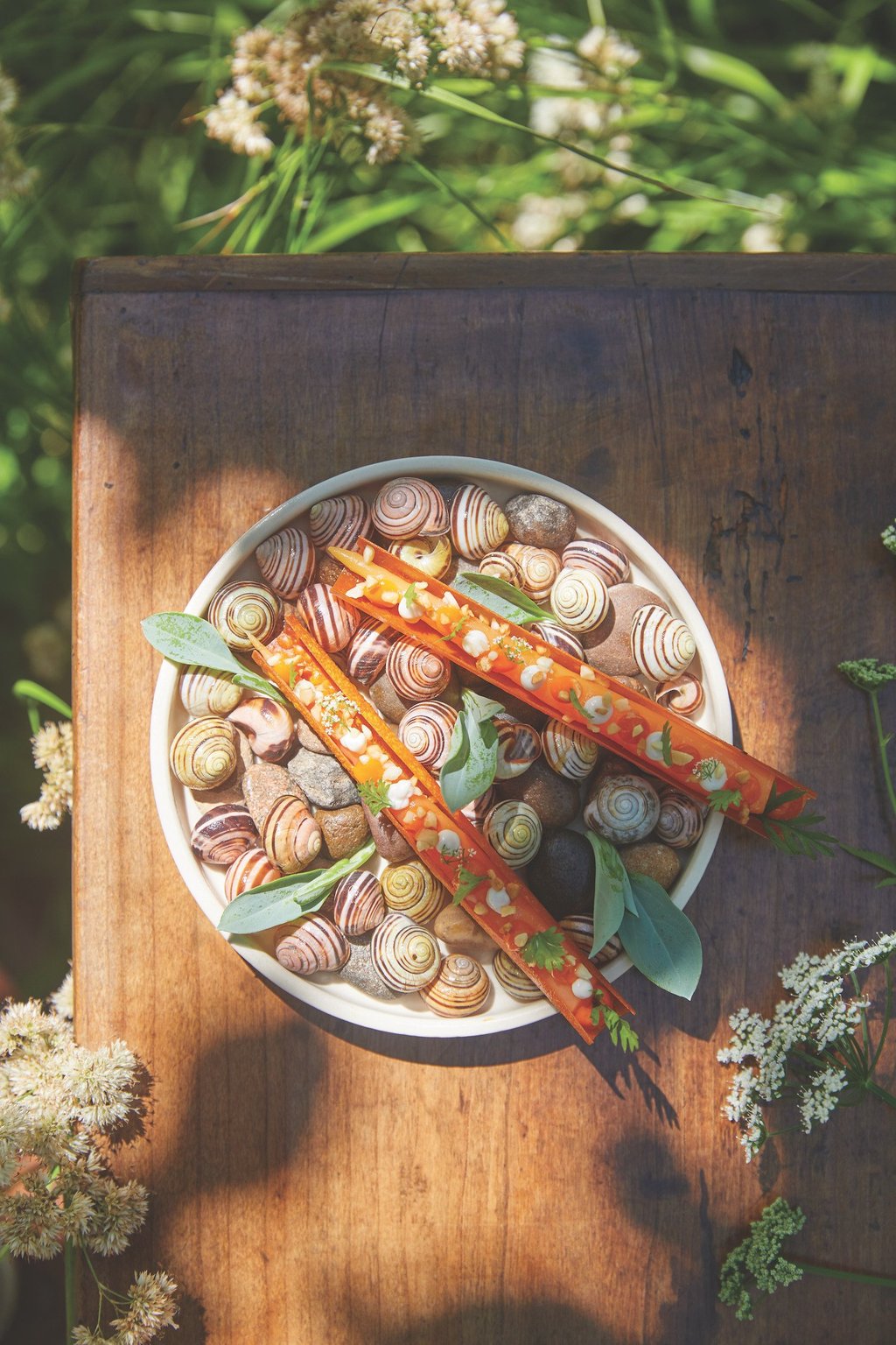 Le Manoir’s carrot and goat’s cheese canape featuring a carrot tuile, carrots and goat’s curd, all from the on-site garden. Photo: Le Manoir