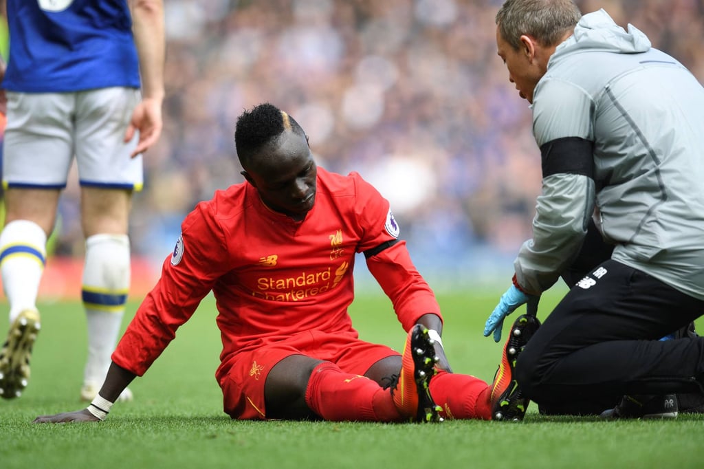 Sadio Mane receives medical attention after picking up an injury during the English Premier League football match between Liverpool and Everton. Photo: AFP