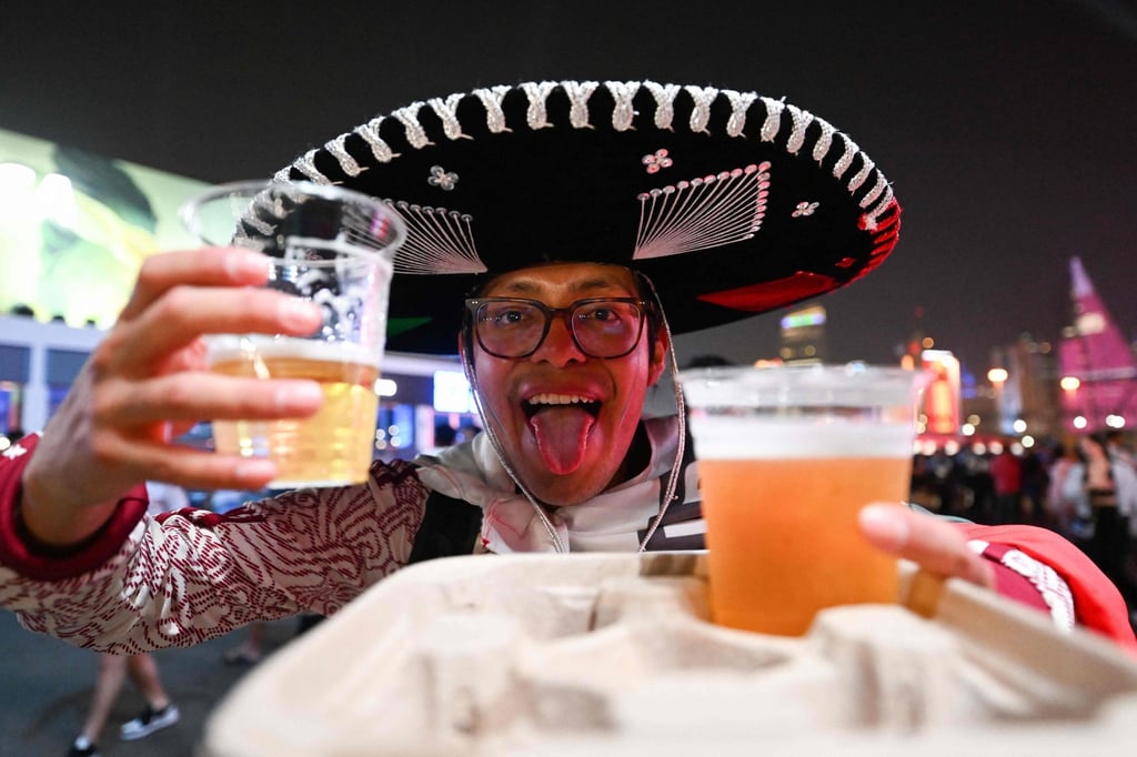 A football supporter holds beers during the Fufa Fan Festival opening day at Al Bidda park. Photo: AFP A football supporter holds beers during the Fufa Fan Festival opening day at Al Bidda park. Photo: AFP