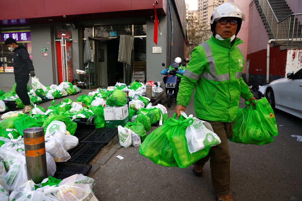 A delivery worker in Beijing picks up goods at a logistics station of an online grocery platform by Meituan. Photo: Reuters A delivery worker in Beijing picks up goods at a logistics station of an online grocery platform by Meituan. Photo: Reuters