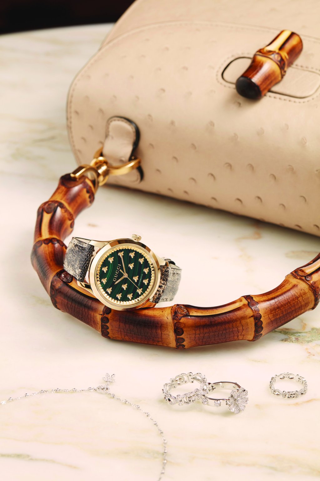 Bamboo 1947 small top handle bag; Flora necklace and ring x 3, all in 18k white gold ring with diamonds; G-Timeless automatic watch with 18k yellow gold case, green malachite stone dial with bees, interchangeable tejus and printed pattern strap.