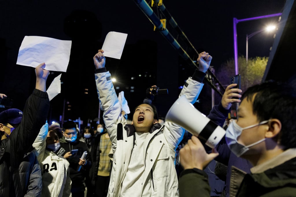 People hold white sheets of paper in protest over Covid-19 restrictions after a vigil for the victims of a fire in Urumqi. Photo: Reuters