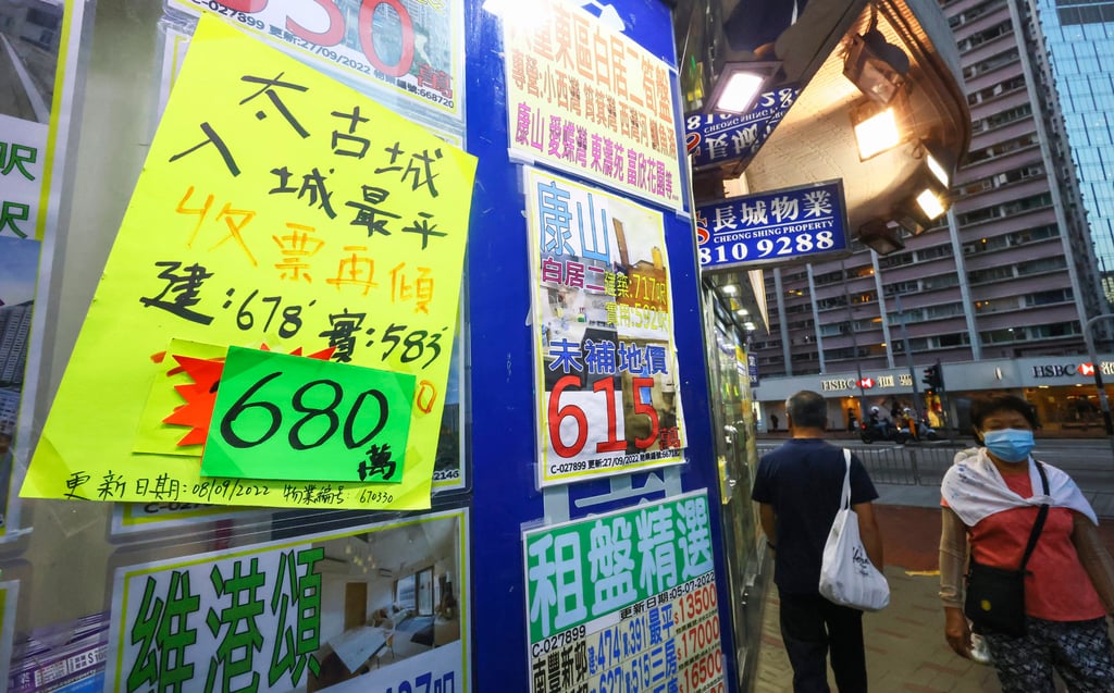 People walk past residential property advertisements displayed in the window of an estate agency in Tai Koo. Photo: Dickson Lee