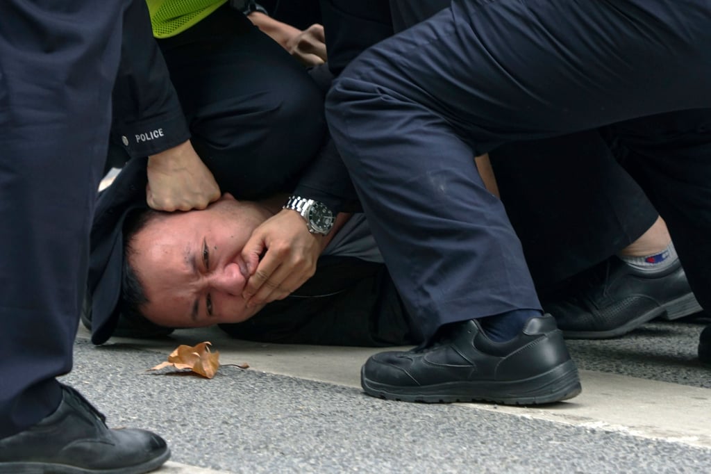 Policemen pin down and arrest a protester during a protest on a street in Shanghai on November 27, 2022. Authorities eased antivirus rules in scattered areas but affirmed China’s severe “zero-Covid” strategy after crowds demanded President Xi Jinping resign during protests against controls that confine millions of people to their homes. Photo: AP Policemen pin down and arrest a protester during a protest on a street in Shanghai on November 27, 2022. Authorities eased antivirus rules in scattered areas but affirmed China’s severe “zero-Covid” strategy after crowds demanded President Xi Jinping resign during protests against controls that confine millions of people to their homes. Photo: AP