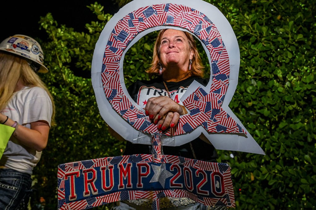 A Trump supporter holds a sign associated with the Qanon conspiracy theory outside his Mar-A-Lago residence in Florida last month. Photo: AFP