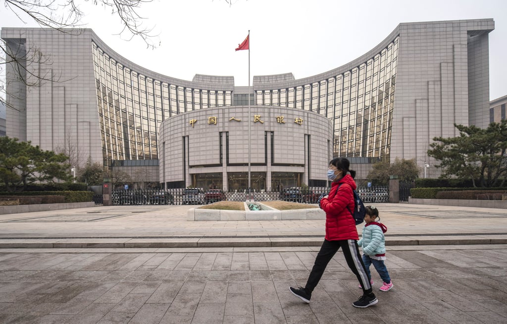 A woman and child walk past the People’s Bank of China building in Beijing on March 4, 2021. Yields on 10-year government bonds rose by the most since early 2019 in November. Photo: Bloomberg