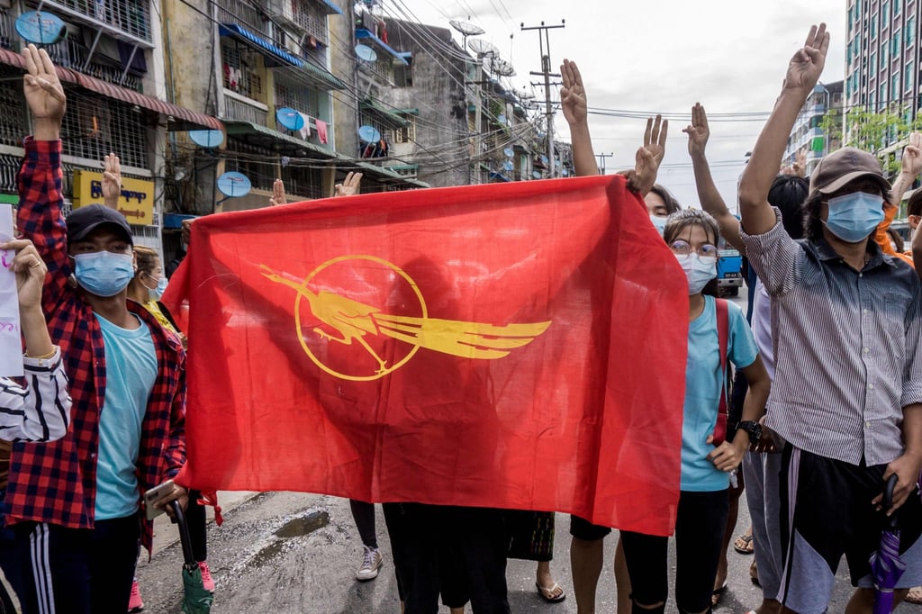 Protesters hold the Myanmar Student Union flag as they make the three-finger salute during an anti-coup demonstration in Yangon on June 13, 2021. Photo: AFP
