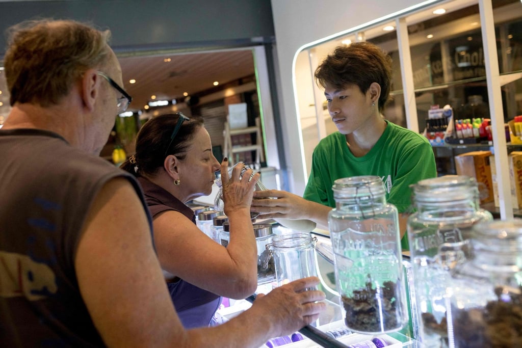 Customers smell a container of cannabis buds at a dispensary in Bangkok. Photo: AFP