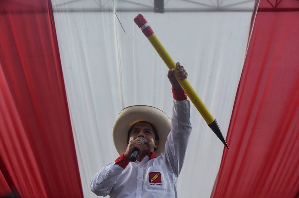 Pedro Castillo delivers a speech as he holds a big pencil, the symbol of his Peru Libre party, during a rally in May 2021. Photo: AFP