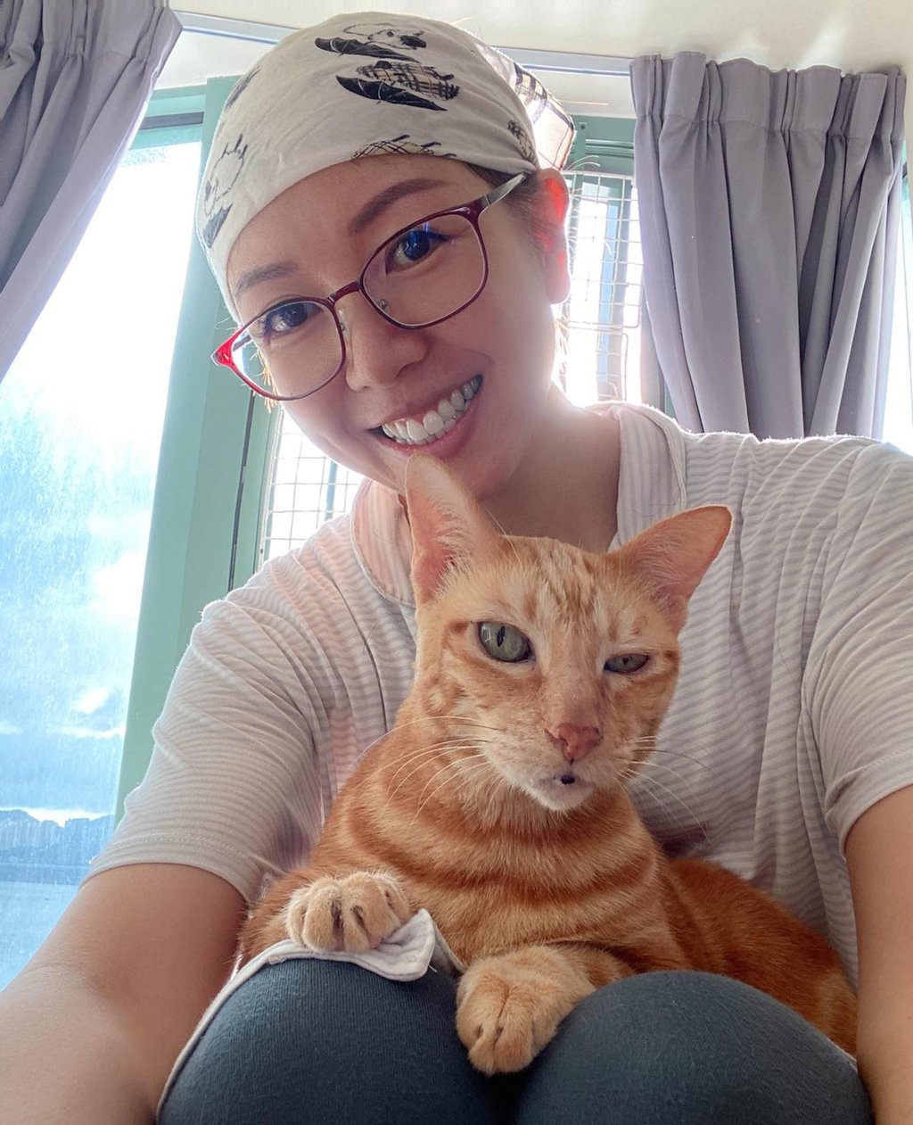 Cindy Cheng’s first photo taken after losing her hair from chemotherapy, with one of her cats. Photo: Cindy Cheng