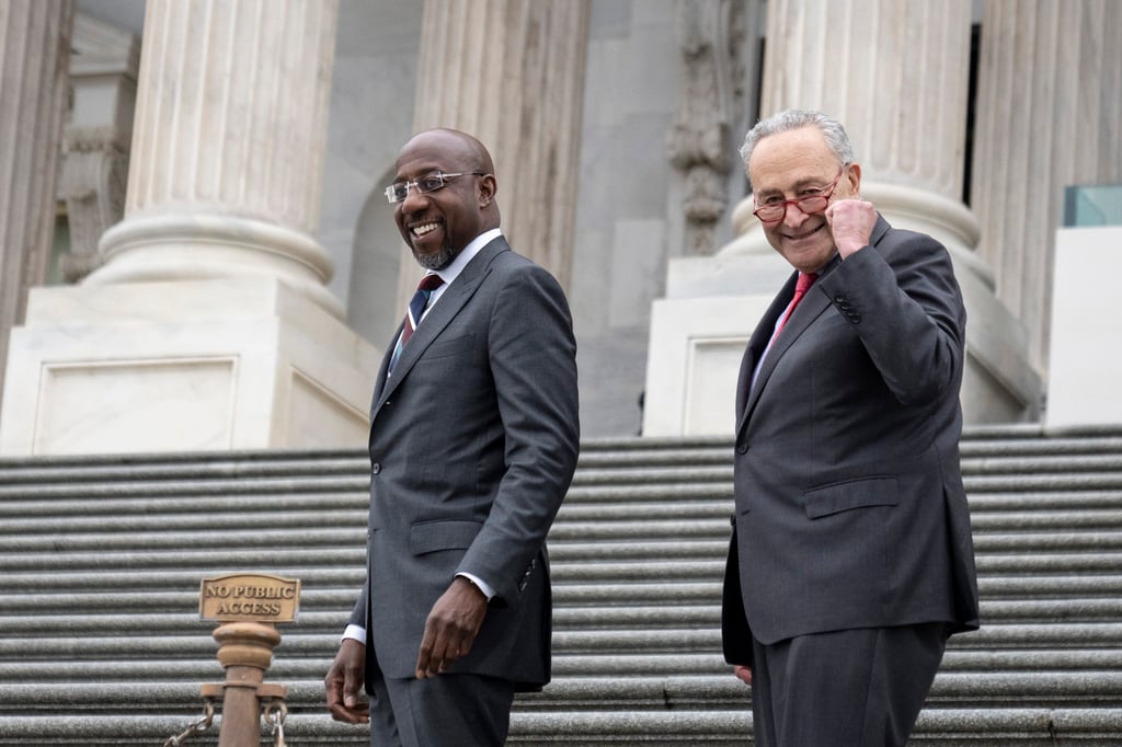 US Senate Majority Leader Chuck Schumer and US Senator Raphael Warnock walk up the Senate steps on Wednesday. Photo: TNS