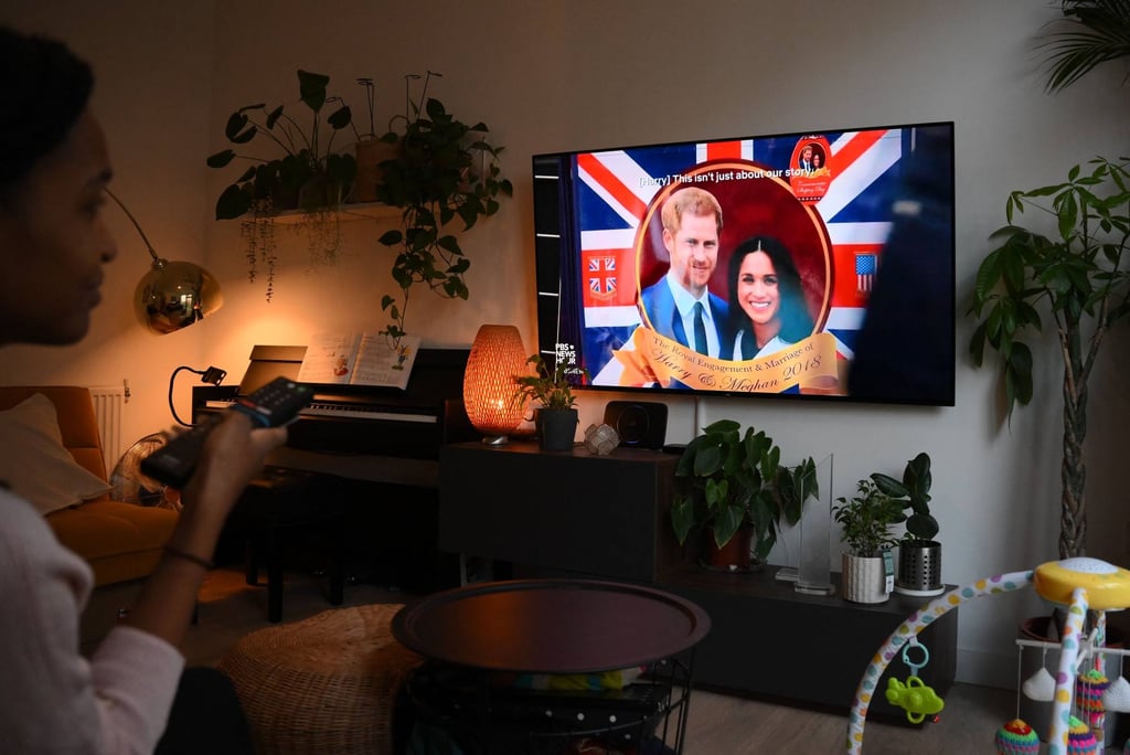 A woman watches an episode of the newly released Netflix docuseries Harry & Meghan about Britain’s Prince Harry, Duke of Sussex, and Meghan, Duchess of Sussex, in London, on December 8. Photo: AFP