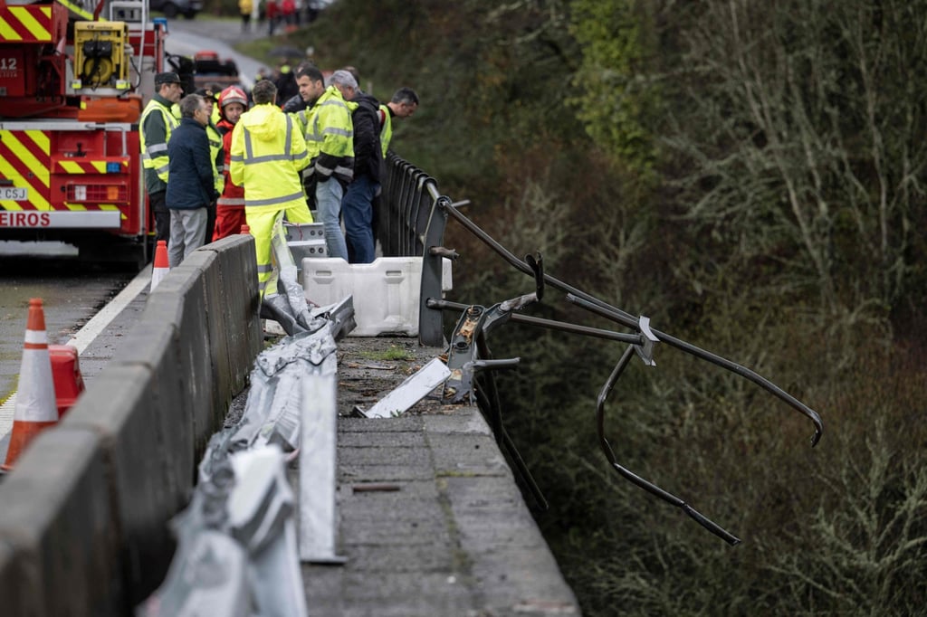 Emergency services members stand on a bridge after a bus plunged into the Lerez river in northwestern Spain on Sunday. Photo: AFP