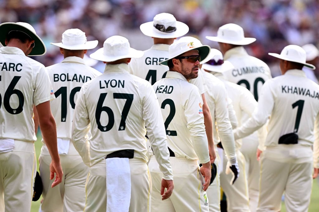 Australia’s Travis Head looks around as the Australian players wear floppy heads in memory of former player Shane Warne. Photo: AFP Australia’s Travis Head looks around as the Australian players wear floppy heads in memory of former player Shane Warne. Photo: AFP