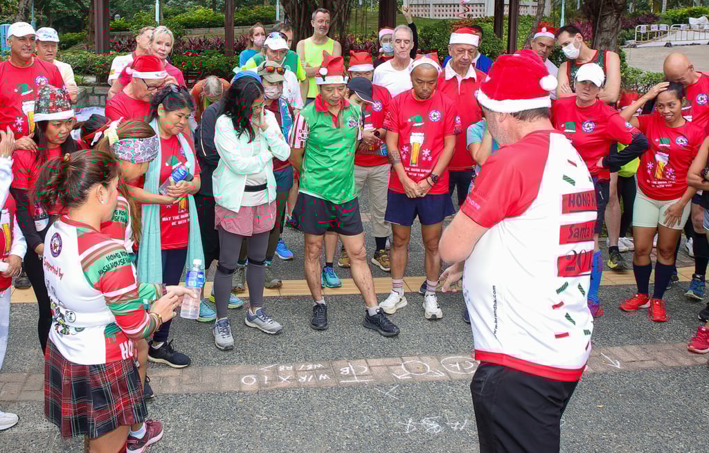 Organiser Mark “Hopeless” Hope (foreground) briefs hashers on the directional chalk markings used to plot the running route. Photo: Bharat Khemlani Organiser Mark “Hopeless” Hope (foreground) briefs hashers on the directional chalk markings used to plot the running route. Photo: Bharat Khemlani