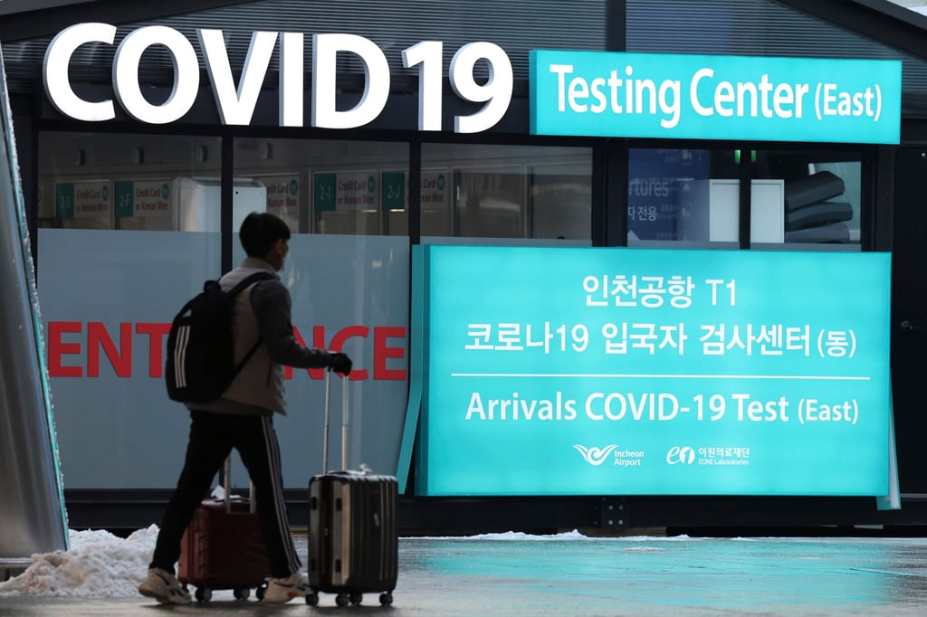 A traveller walks near a banner for the coronavirus testing centre at Incheon International Airport on Friday. South Korea has imposed mandatory Covid-19 tests on visitors from China. Photo: Yonhap via AP