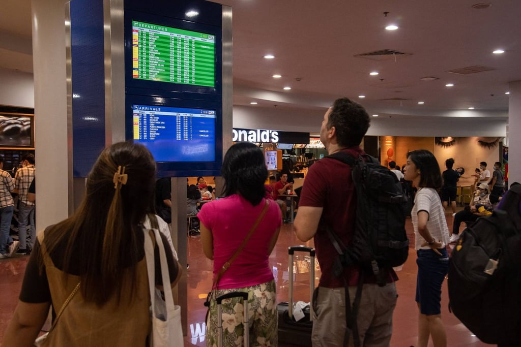 Passengers look at a screen showing flight information at terminal 3 of Ninoy International Airport in Pasay, Metro Manila on Sunday. Photo: AFP