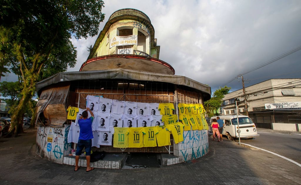 A vendor sells T-shirts bearing the image of Pele outside the Vila Belmiro stadium in Santos. Photo: AFP