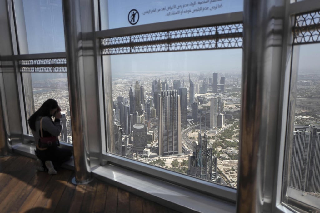 Tourists take photos at the top of Dubai’s Burj Khalifa, the world’s tallest building. Photo: AFP