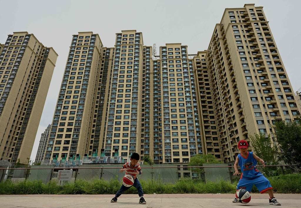Children play in front of a housing complex constructed by Chinese property developer Evergrande in Beijing. Photo: AFP Children play in front of a housing complex constructed by Chinese property developer Evergrande in Beijing. Photo: AFP