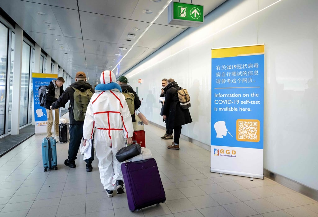 Travellers arriving from China walk past information banners and receive free Covid-19 self-test kits at Amsterdam’s Schiphol Airport on Wednesday. Photo: ANP/AFP