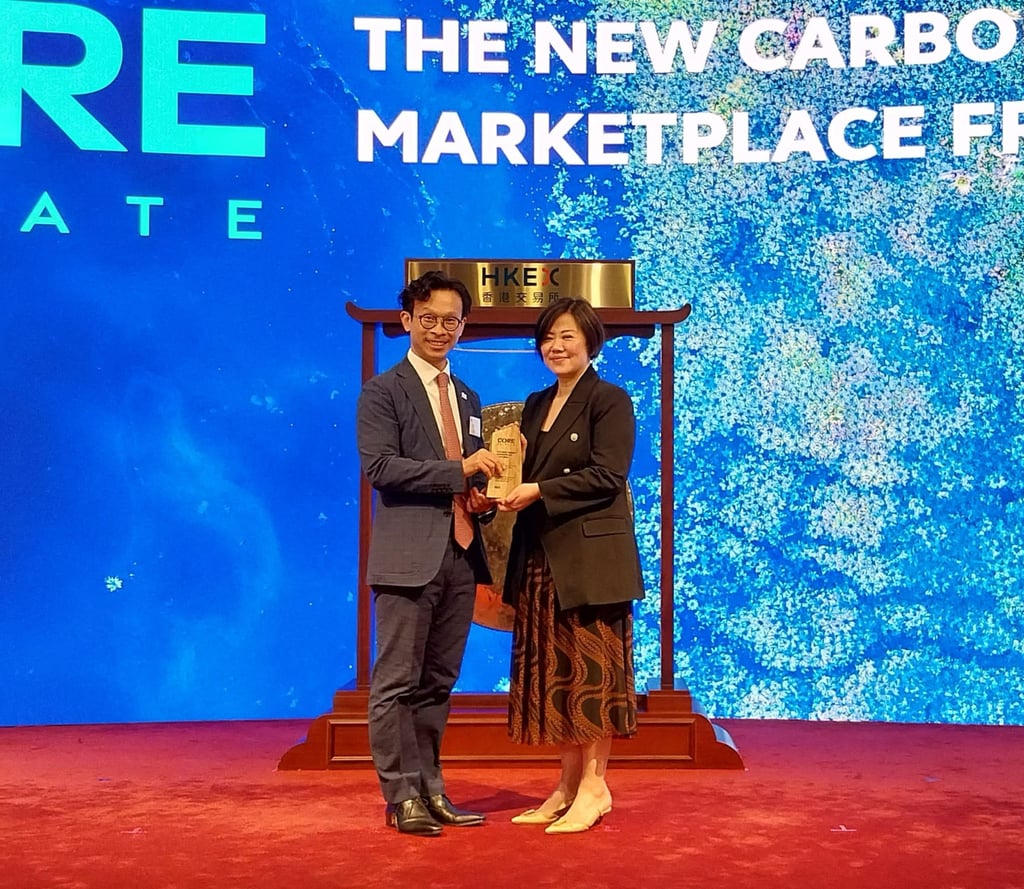 Glenda So (right), co-head of markets of Hong Kong Exchanges and Clearing (HKEX), presented a trophy to Hong Kong and China Gas chief investment officer Alan Chan Ying-lung (left), at the launch ceremony of international carbon marketplace Core Climate. Photo: Handout