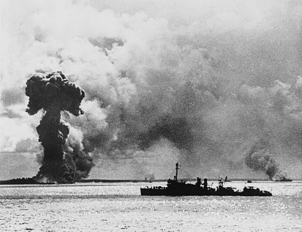 A US warship patrols off the coast of Darwin in northern Australia after a Japanese air strike in 1942. The smoke column on the left is from an exploding Australian ship said to have been loaded with bombs. Photo: AP