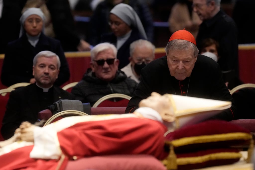 Pell (right) stands next to the body of the late Pope Benedict XVI lying in state inside St. Peter’s Basilica at The Vatican earlier this month. Photo: AP Pell (right) stands next to the body of the late Pope Benedict XVI lying in state inside St. Peter’s Basilica at The Vatican earlier this month. Photo: AP
