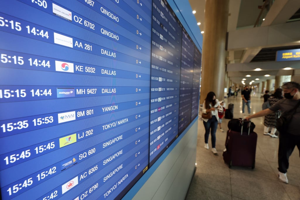 Overseas passengers walk past an arrival board at Incheon airport in Seoul. File photo: EPA-EFE Overseas passengers walk past an arrival board at Incheon airport in Seoul. File photo: EPA-EFE