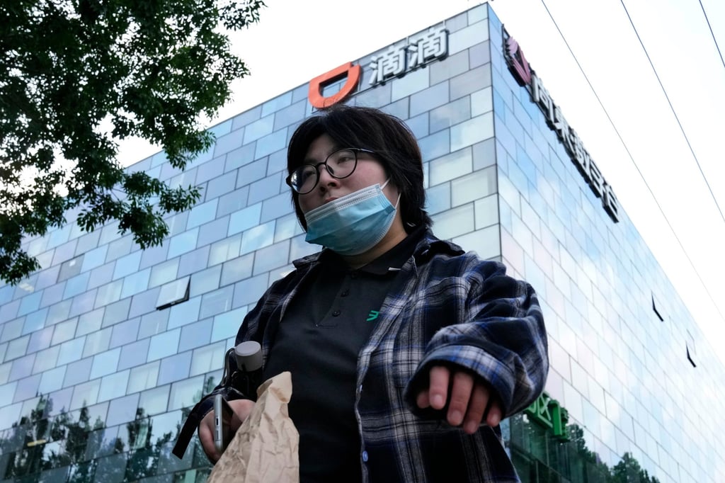 A woman walks past the headquarters of ride-hailing giant Didi Chuxing in Beijing on July 16, 2021. Photo: AP A woman walks past the headquarters of ride-hailing giant Didi Chuxing in Beijing on July 16, 2021. Photo: AP