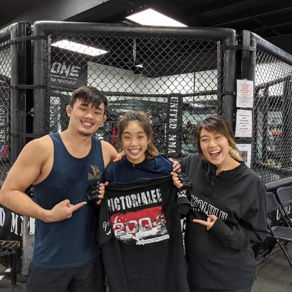 Christian Lee (left) and Angela Lee (right) celebrate with younger sister Victoria Lee after she signs with Evolve MMA. Christian Lee (left) and Angela Lee (right) celebrate with younger sister Victoria Lee after she signs with Evolve MMA.